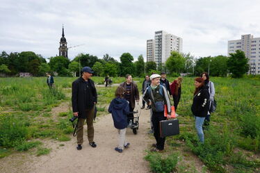 Eine Gruppe Geschichtsinteressierter lässt sich auf der Brache des ehemaligen Plattenwerks Dresden-Johannstadt die Hintergründe erklären.