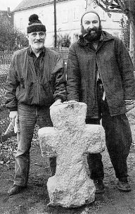 Kaditzsch (Kreis Grimma). Das kleine Steinkreuz fand sich im Scheunenfundament an der Südseite des Dorfplatzes und wird gerade neben der Fundstelle aufgestellt. Von links: Herr Weber vom Archäologischen Landesamt Sachsen und Herr Unteidig vom Kreismuseum Grimma.